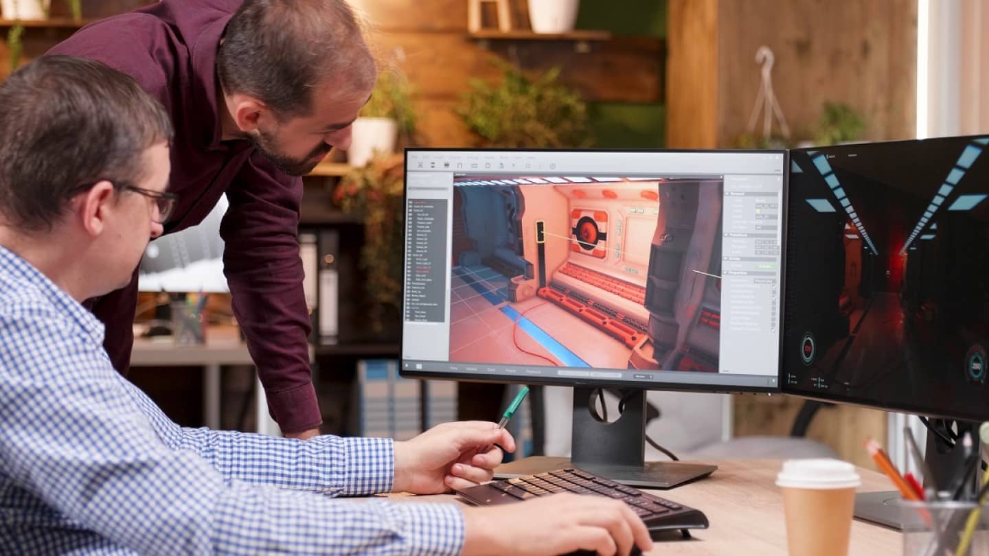 Graphic designer in gaming industry talking detail with his colleague analyzing 3d design level
